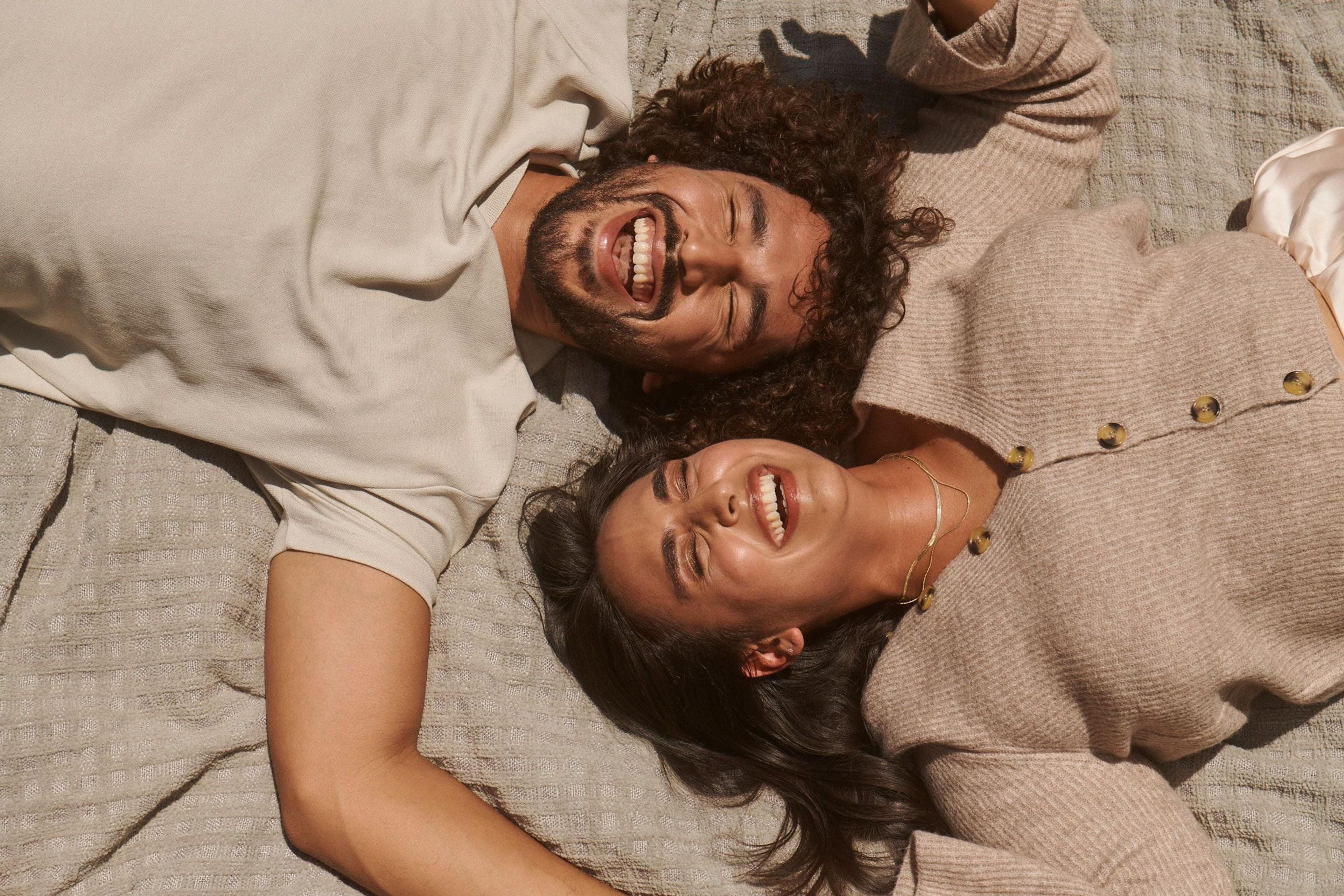 Two people lying down and laughing together (mobile)